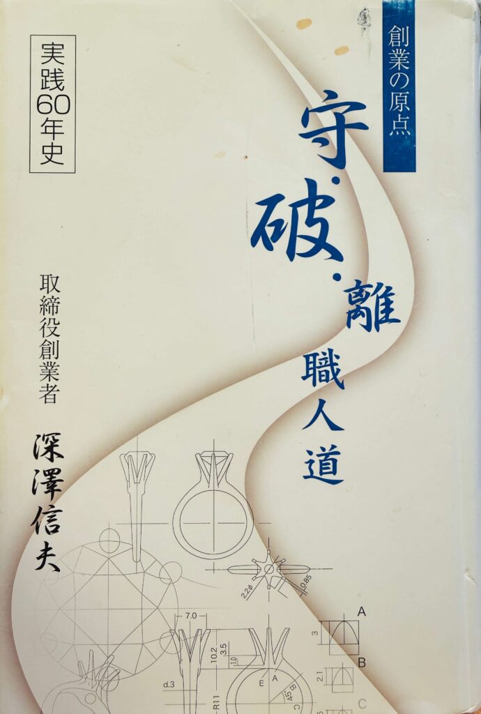 Japanese book cover featuring large blue kanji '守破離' with a blue vertical banner reading '創業の原点'; side text includes '実践60年史' and author name 深澤信夫, indicating a history/guide to founding principles.