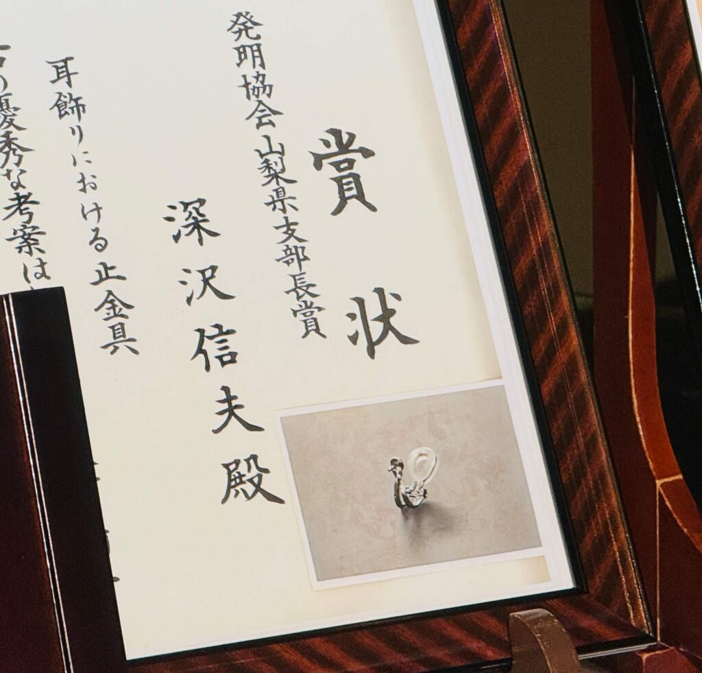 Page with vertical Japanese kanji characters framed in a dark wooden frame.